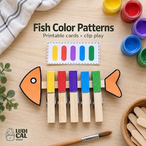 Peut inclure: Une carte imprimable Fish Color Patterns avec cinq rectangles colorés, un squelette de poisson en papier fixé sur un bâtonnet en bois, et cinq pinces à linge en bois colorées clipsées sur le bâtonnet en jaune, rouge, violet, bleu et vert.