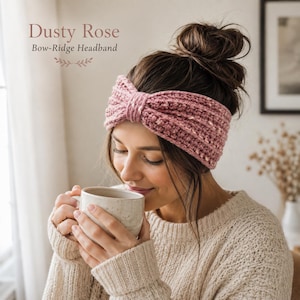 Può includere: Una fascia all'uncinetto color rosa polvere con un dettaglio a fiocco centrale e un motivo a coste testurizzato. Il testo Dusty Rose Bow-Ridge Headband è visibile nell'angolo in alto a sinistra. La fascia è indossata intorno alla testa.