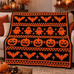 Può includere: Una coperta rettangolare all'uncinetto con un motivo ripetuto di pipistrelli, fantasmi e zucche arancioni su sfondo nero. Il design include file orizzontali di bordi a scacchi e piccole forme a croce che separano ogni motivo.