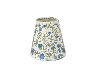 May include: A white lampshade with a blue and green floral pattern.