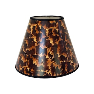 May include: A brown and black patterned lampshade with a black trim. The lampshade is cone-shaped and has a unique animal print design.