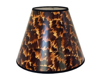 May include: A brown and black patterned lampshade with a black trim. The lampshade is cone-shaped and has a unique animal print design.