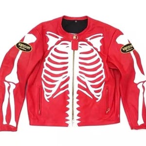 Könnte beinhalten: Eine leuchtend rote Lederjacke mit einer weißen Skelett-Brustkorb-Grafik auf der Vorderseite und weißen Armknochen-Grafiken auf den Ärmeln. Die Jacke hat einen goldfarbenen Frontreißverschluss und schwarze Vanson Leathers-Aufnäher an den Oberarmen.