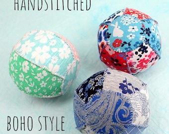 May include: Three hand-stitched fabric balls in different patterns. The balls are made from patchwork fabric in shades of blue, green, and red. The text "HANDSTITCHED" and "BOHO STYLE" are visible in the image.