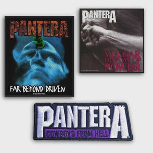 Könnte beinhalten: Drei rechteckige Stoffaufnäher mit Pantera-Albumcovern. Einer zeigt einen blauen Bohrer in einem Schädel mit dem Text Far Beyond Driven. Ein anderer zeigt eine Faust, die auf ein Gesicht schlägt, mit dem Text Vulgar Display of Power.