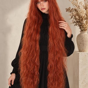May include: A long, wavy, copper-red wig featuring straight-cut bangs that frame the forehead. The hair has a textured, voluminous appearance with a vibrant, deep orange-red hue, cascading down past the waist in loose, flowing waves.