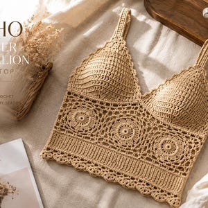 May include: A beige crochet crop top featuring a V-neckline with molded cups and a lower section composed of three circular flower medallion motifs. The garment has two shoulder straps and a scalloped hemline with intricate openwork detailing.