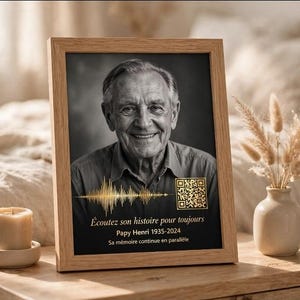 Peut inclure: Un cadre en bois clair contenant un portrait en noir et blanc d'un homme âgé. Sous le portrait se trouvent un graphique d'onde sonore doré, un QR code doré et le texte : Écoutez son histoire pour toujours, Papy Henri 1935-2024, Sa mémoire continue en parallèle.