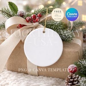 May include: A round white ceramic ornament with a gold hanging string, positioned in front of a brown gift box wrapped with a beige ribbon, decorated with frosted pine branches, red berries, and a pinecone, featuring text overlays.