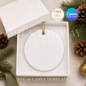May include: A white circular ceramic ornament with a gold hanging string, presented inside an open white square gift box. The ornament is blank and smooth, featuring a centered hole for the string. The box is set against a festive background.
