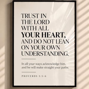 May include: A framed wall art print featuring black text on a light beige background. The text reads: TRUST IN THE LORD WITH ALL YOUR HEART, AND DO NOT LEAN ON YOUR OWN UNDERSTANDING. In all your ways acknowledge him, and he will make straight your paths. PROVERBS 3:5-6.