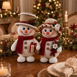 May include: Two crocheted snowman figures with white bodies, red scarves, and brown buttons. One wears a tan top hat with holly, the other a tan bonnet with flowers and holly. They hold a small gift and a floral sprig, respectively.