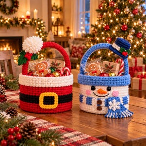 May include: Two round crochet baskets with handles. The left basket is red with a white trim, a black belt, and a yellow buckle. The right basket is white with a blue trim, a blue scarf, and a snowman face. Both contain holiday treats.