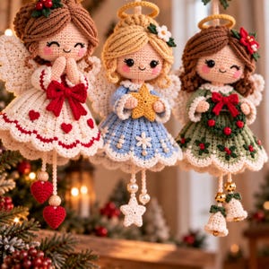 May include: Three crocheted angel ornaments with yarn hair, halos, and wings. The left angel wears a white dress with red hearts and bows. The center angel wears a blue dress with a yellow star. The right angel wears a green dress with a wreath.