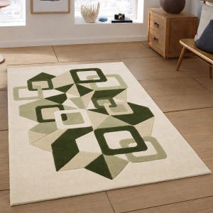 May include: A rectangular area rug featuring a cream-coloured background with a geometric pattern of overlapping squares and triangles in various shades of forest green, olive green, and light sage green, creating a layered, three-dimensional effect.