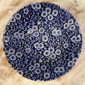 Puede incluir: Un cuenco de cerámica con estampado floral azul y blanco. El cuenco tiene un fondo blanco con un estampado floral azul.