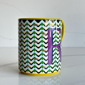 Op de afbeelding: Een set van drie keramische mokken met een gespikkelde, matte afwerking. De mokken zijn in de kleuren cr&egrave;me, lichtgrijs en donkergrijs. Elke mok heeft een eenvoudig, minimalistisch ontwerp en een afgeronde handgreep.
