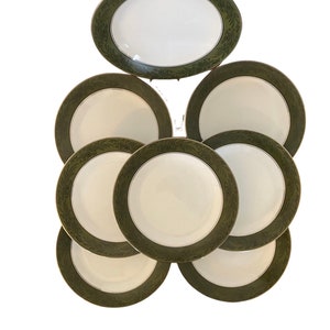 May include: Set of eight white ceramic dinner plates with a green and gold floral border.