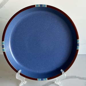 May include: A set of three ceramic mugs with a speckled, matte finish. The mugs are in shades of cream, light gray, and dark gray. Each mug has a simple, minimalist design, perfect for coffee or tea.