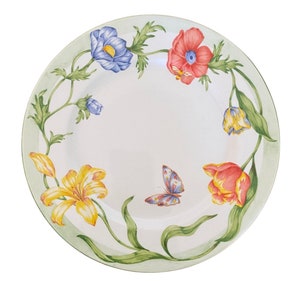 Pode incluir: Um prato de cerâmica branco com uma borda verde e um design floral. O design apresenta lírios amarelos, tulipas vermelhas e rosas, anémones azuis e uma borboleta.
