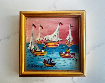 Pintura a óleo em miniatura emoldurada de arte folclórica haitiana de Ernst Joassaint, representando uma cena de barco de pesca.