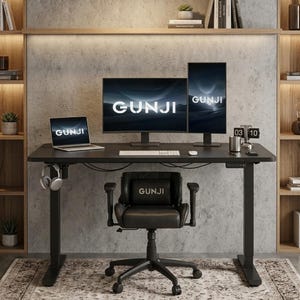 Op de afbeelding: Een zwart sta-bureau met een laptop, twee monitoren en een toetsenbord, allemaal met de tekst GUNJI. Een zwarte bureaustoel met de tekst GUNJI op de hoofdsteun staat voor het bureau, dat is voorzien van een koptelefoonhaak.
