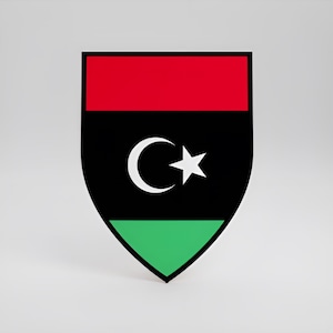 Könnte beinhalten: Ein schildförmiges Emblem mit einem horizontalen dreifarbigen Design, bestehend aus einem roten oberen Streifen, einem schwarzen mittleren Streifen und einem grünen unteren Streifen. In der Mitte des schwarzen Streifens befindet sich ein weißer Halbmond.