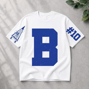 May include: A white short-sleeve t-shirt featuring a large blue letter B in the center. The left sleeve displays a blue pennant graphic with the text BULLDOGS, while the right sleeve features the blue text #10 in a bold, block-style font.