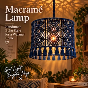 May include: A dark blue cylindrical macramé lamp shade featuring intricate knotted patterns and a row of hanging tassels along the bottom edge. The lamp is suspended by a braided cord and emits a warm glow through the woven fiber structure.