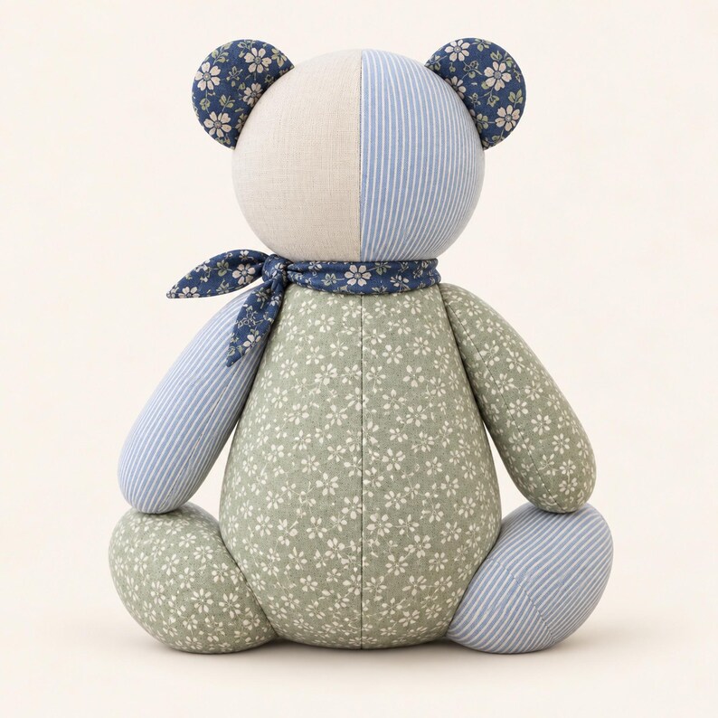 Peut inclure: Un ours en peluche fabriqu&eacute; &agrave; partir de divers tissus &agrave; motifs. La t&ecirc;te est divis&eacute;e entre du cr&egrave;me uni et des rayures bleu et blanc. Le corps et les membres pr&eacute;sentent un tissu floral vert sauge et un tissu &agrave; rayures bleues. Une &eacute;charpe florale bleu fonc&eacute; est nou&eacute;e autour du cou.