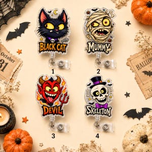 May include: Four acrylic badge reels featuring Halloween characters: a black cat with a skull collar, a wrapped mummy, a red devil with a trident, and a skeleton wearing a top hat and purple bow tie. Each reel includes the character name in text.