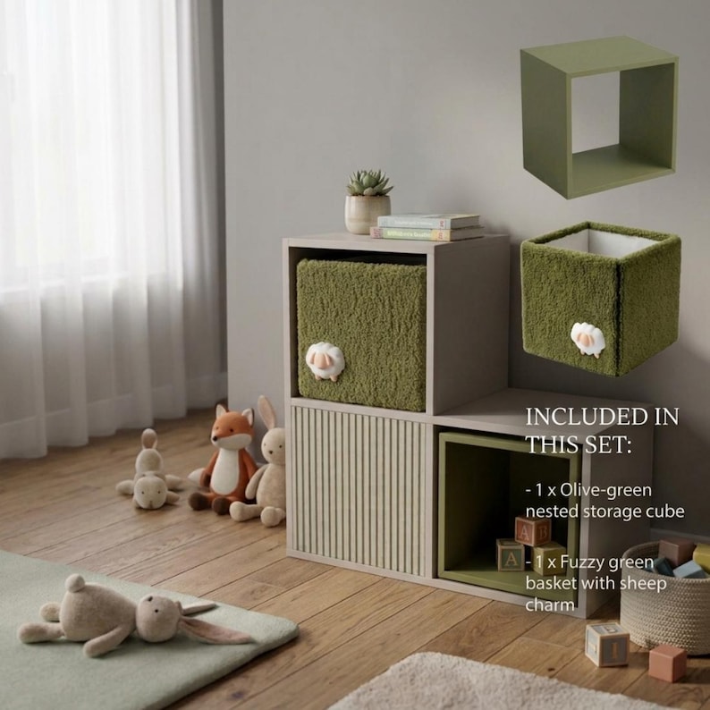 May include: A modular storage unit with two light beige cubbies, one featuring vertical slats. Included are an olive-green nested storage cube and a fuzzy olive-green basket with a white sheep charm. Text reads: INCLUDED IN THIS SET.