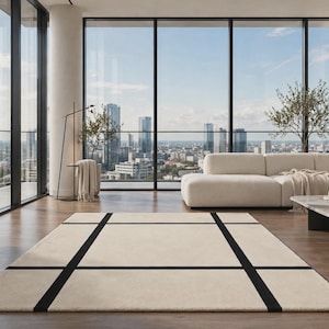 May include: A rectangular area rug featuring a cream-colored base with a bold, black grid pattern consisting of two horizontal and two vertical lines that intersect to create a structured, geometric design across the entire surface of the rug.