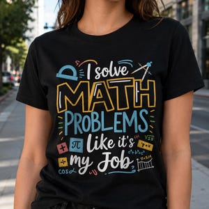 Pode incluir: Uma t-shirt preta de manga curta com o texto "I solve MATH PROBLEMS like it's my Job" em amarelo, azul e branco. O design inclui símbolos matemáticos coloridos, um transferidor, um compasso e várias equações.