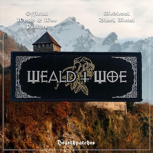 May include: A rectangular black embroidered patch featuring the white text WEALD + WOE with a gold-coloured floral design in the centre. The patch is bordered by a white geometric pattern and includes the text Official Weald & Woe Patches, Medieval Black Metal, and Hearthpatches.