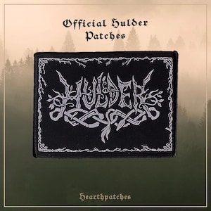 Op de afbeelding: Een rechthoekige zwarte geborduurde patch met de witte tekst HULDER in een gestileerd, grillig lettertype. Het ontwerp bevat ingewikkelde witte rankachtige randen en een centraal vlechtwerk-element. De tekst Official Hulder Patches staat erboven.