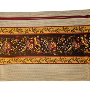 May include: A rectangular zippered pouch featuring a beige mesh top and bottom section. The center panel displays a dark brown background with a horizontal floral pattern in shades of red, yellow, and green, bordered by thin yellow and red stripes.