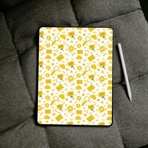 May include: A rectangular tablet featuring a white background with a repeating yellow pattern of web-related icons including magnifying glasses, envelopes, speech bubbles, gears, clouds, and the text WEB. A white stylus is positioned to the right.