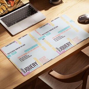 May include: A rectangular desk mat featuring a white background with repeating multi-colored text including JQUERY, PROGRAMMING, FUTURE TECH, CLOUD COMPUTING, and phrases like TALK IS CHEAP. SHOW ME THE CODE and CODE FOR HUMANS, NOT JUST COMPUTERS.