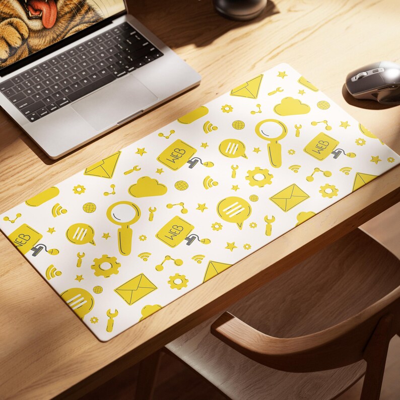 May include: A rectangular desk mat featuring a white background with a repeating pattern of yellow web-related icons including magnifying glasses, envelopes, speech bubbles, gears, wrenches, cloud shapes, and computer monitors labeled with the text WEB.