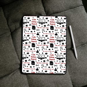 May include: A rectangular tablet featuring a white background with a repeating pattern of black programming icons and red text. The text includes phrases like Code Debug Repeat, Talk less. Code more, and The truth is in the code. A white stylus is adjacent.