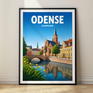 May include: A framed travel poster featuring a vibrant illustration of Odense, Danmark. The scene depicts a historic brick church with a tall spire, yellow buildings, a stone bridge over a canal, and yellow flowers in the foreground under a blue sky.