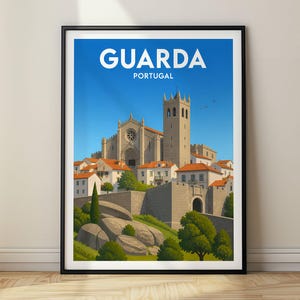 May include: A framed travel poster featuring the city of Guarda, Portugal. The illustration depicts a stone cathedral with a tall tower, surrounded by white buildings with orange roofs, set against a clear blue sky. The text reads GUARDA PORTUGAL.