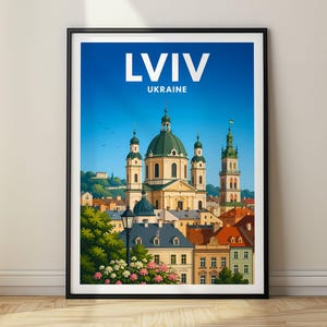 May include: A framed travel poster featuring a vibrant illustration of Lviv, Ukraine. The artwork displays a central cathedral with a green dome, surrounded by historic buildings, lush green trees, and flowers, all set against a clear blue sky.