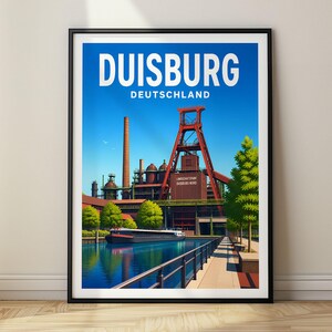 Op de afbeelding: Een ingelijste reisposter met de tekst DUISBURG DEUTSCHLAND. De illustratie toont een rood industrieel schachtgebouw, een hoge bakstenen schoorsteen en een donkere aak op een kanaal onder een blauwe lucht met groene bomen.