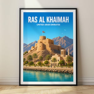 May include: A framed travel poster featuring a tan stone fort on a rocky hill with mountains in the background, palm trees, and a blue waterfront. The text reads RAS AL KHAIMAH UNITED ARAB EMIRATES in white capital letters against a blue sky.