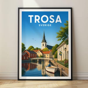 Puede incluir: Un póster de viaje enmarcado con una vista pintoresca de Trosa, Sverige. La ilustración muestra un canal con un bote blanco, un puente, casas rojas y amarillas, y un campanario bajo un cielo azul. El texto Trosa Sverige aparece en la parte superior.