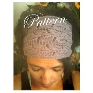 May include: A close-up of a woman wearing a light purple knitted headband with a lacy pattern. The headband is worn over her forehead and covers her ears. The headband is made of a soft, delicate yarn.