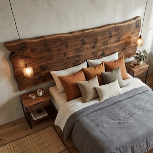 Può includere: Una camera da letto con una grande testiera in legno a bordo vivo montata sopra un letto con piumino grigio, lenzuola bianche e diversi cuscini decorativi nei toni ruggine, oliva e crema. Presenti due comodini e una poltrona grigia.