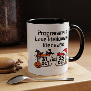 May include: A white ceramic mug with a black handle and interior rim. The mug features the text "Programmers Love Halloween Because" above an illustration of two calendars showing "31 OCT" with a witch hat and pumpkin, and "25 DEC" with a Santa hat.